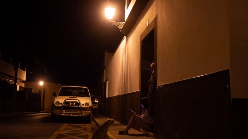 Des membres d'une famille espagnole se rafraîchissent devant leur maison à Séville, le 12 août 2021. 