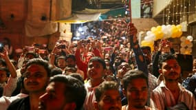Des personnes admirent le feu d'artifice illuminant le ciel à l'occasion de la fête hindoue de "Dev Deepawali" sur les rives du Gange à Varanasi, le 5 novembre 2025.