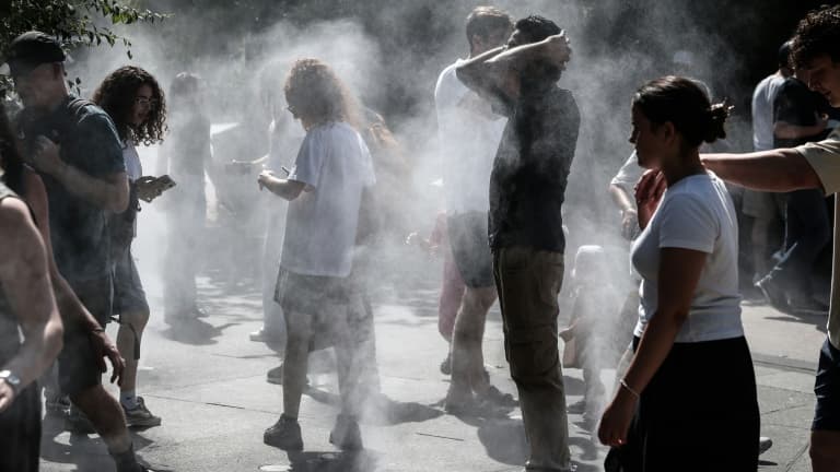 Des personnes se rafraîchissent au milieu de brumisateurs à Paris, le 1er juillet 2025, en période de canicule