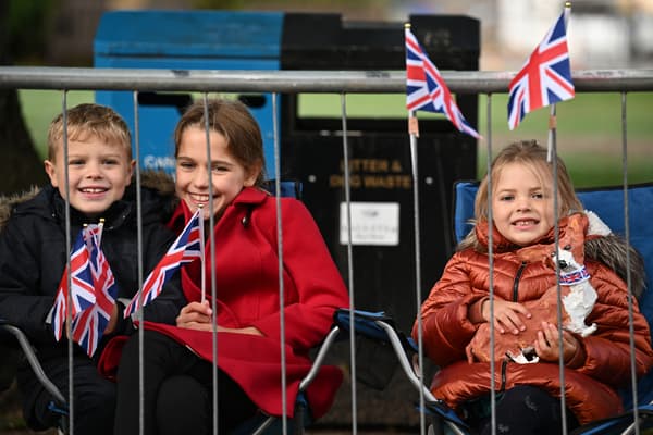 Children wait for the passage of the coffin of Queen Elizabeth II, in Ballatier, Scotland, September 11, 2022