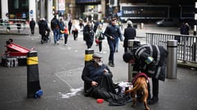 Un agent de sécurité parle à un sans-abri devant la gare de Waterloo à Londres, le 15 avril 2024.