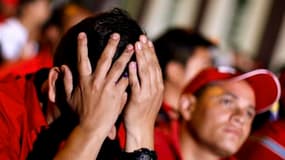 Réaction d'un partisan d'Hugo Chavez à l'annonce du résultat du vote devant le palais de Miraflores à Caracas. L'opposition vénézuélienne a privé dimanche le Parti socialiste de la majorité des deux tiers à l'Assemblée nationale, où la formation du présid