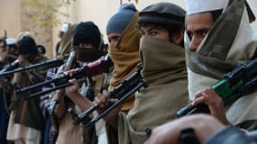 Des anciens soldats talibans posent avec leurs armes avant de les remettre à l'armée afghane.