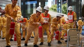 Des employés de la Mori Building Company s'entraînent à la lutte contre les incendies dans le cadre d'un exercice de simulation de tremblement de terre à Tokyo, le 1er septembre 2023