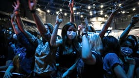 Les gens applaudissent lors d'un concert du DJ français Etienne de Crecy et du groupe pop Indochine à l'AccorHotels Arena de Paris le 29 mai 2021.