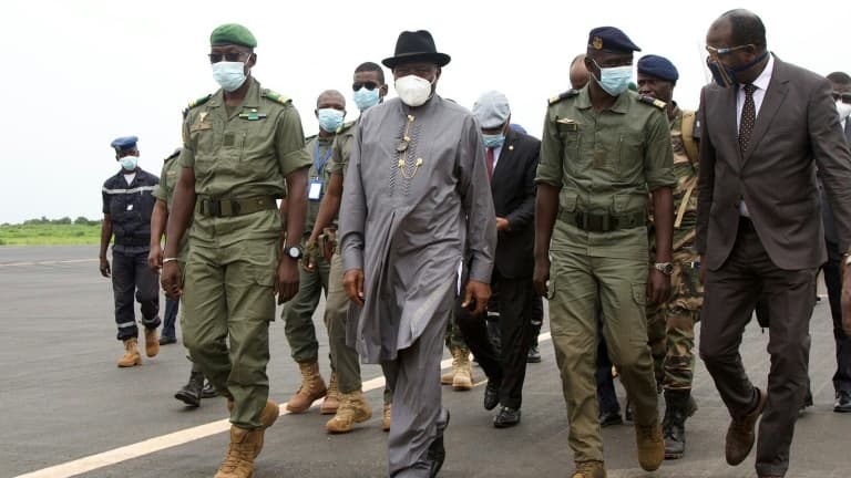 L'ancien président nigérian Goodluck Jonathan, chef de la délégation ouest-africaine envoyée au Mali, à côté de Malick Diaw, vice-président du Comité national pour le salut du peuple, à l'aéroport de Bamako, le 22 août 2020