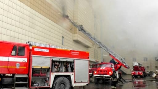 Photo obtenue auprès du Ministère de situations d'urgence russe le 25 mars 2018 montrant des camions de pompiers luttant contre un incendie dans un centre de commercial de Kemerovo, ville industrielle en Sibérie occidentale