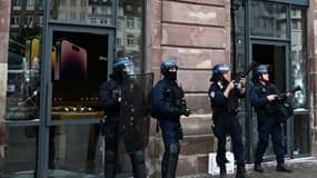 Des agents de police gardent l'entrée d'un magasin Apple, sur la place Kléber, au centre-ville de Strasbourg, le 30 juin 2023.