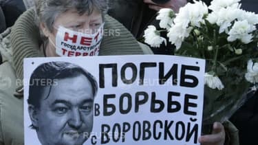 Une femme brandit le portrait de Sergueï Magnitski, pendant une manifestation clandestine à Moscou le 15 décembre 2012 contre le président Vladimir Poutine.