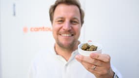 Philip Schetter, PDG de Cantourage, montre un échantillon de fleurs de cannabis provenant de la production de l'entreprise dans un lieu non divulgué en Bavière, dans le sud de l'Allemagne, le 29 avril 2025. Cantourage produit du cannabis médical et l'industrie est en plein essor depuis la légalisation en 2024. (légende AFP via Google traduction)