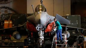 Un membre d'équipage effectue des contrôles sur un chasseur Rafale à bord du porte-avions Charles-de-Gaulle, d'où s'élancent les avions français qui participent à l'opération militaire en Libye. /Photo prise le 26 mars 2011/REUTERS/Benoît Tessier