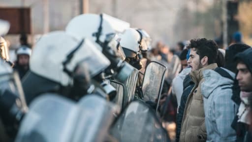 Migrants et réfugiés face-à-face avec la police grecque qui leur interdit de passer la frontière avec la Macédoine, le 3 décembre 2015, à Idomeni, en Grèce