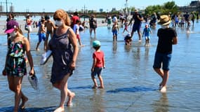 Des personnes se rafraîchissent sur un "miroir d'eau" à Bordeaux, le 6 août 2020 