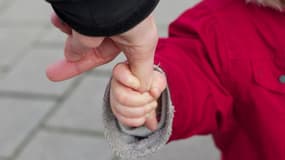 Image d'illustration - un enfant tenant la main d'un adulte