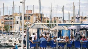 Des touristes assis à la terrasse d'un restaurant du port de Gruissan, dans l'Aude en juillet 2014.