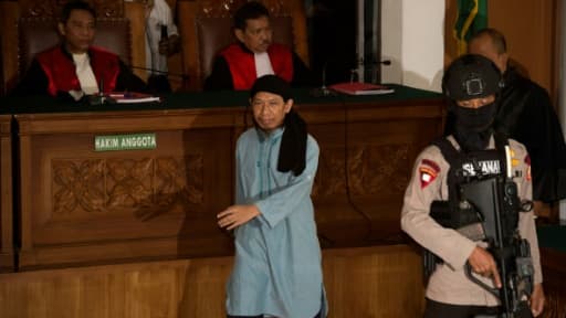 Le prédicateur islamiste indonésien Aman Abdurrahman (C) à son arrivée le 22 juin 2018 au tribunal de Jakarta qui l'a condamné à la peine capitale pour avoir ordonné les attentats suicide de 2016 dans la capitale indonésienne