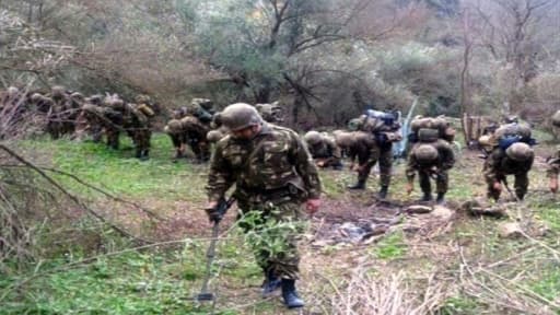 Photo fournie le 16 janvier 2015 par le ministère de la Défense algérien montrant des soldats experts en déminage sondant le sol d'une zone où a été enterré le corps d'Hervé Gourdel, un touriste français décapité par des islamistes