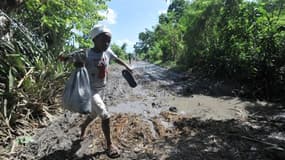 Un enfant traverse un champ dévasté d'Haïti. 51 personnes sont mortes dans le pays après le passage du cyclone Sandy.