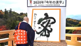 Seihan Mori, maître de l'ancien temple Kiyomizu, utilise la calligraphie pour écrire le caractère chinois «mitsu», qui a été sélectionné comme le meilleur kanji pour symboliser l'année de 2020 au temple de Kyoto, dans l'ouest du Japon, le 14 décembre 2020.
