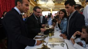 Le président Emmanuel Macron (G) rencontre des jeunes visiteurs à l'Elysée, lors des journées du patrimoine, le 15 septembre 2018