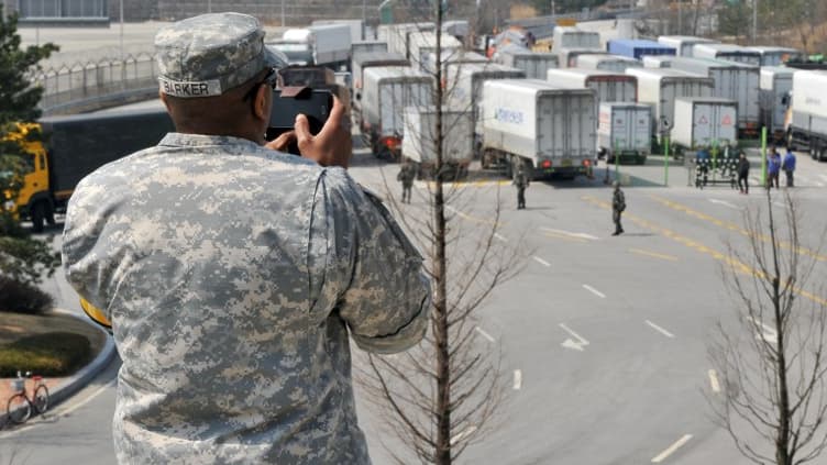 Un soldat américain photographie des camions Sud Coréens forcés de revenir du site de Kaesong le mercredi 3, 2013.