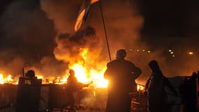 Des manifestants font face à la police, mardi soir, à Kiev, sur la place de l'Indépendance en flammes.