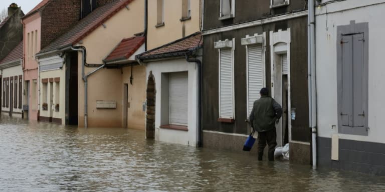 Un habitant devant sa maison dans une rue inondée de Neuville-sous-Montreuil, le 13 novembre 2023 dans le Pas-de-Calais