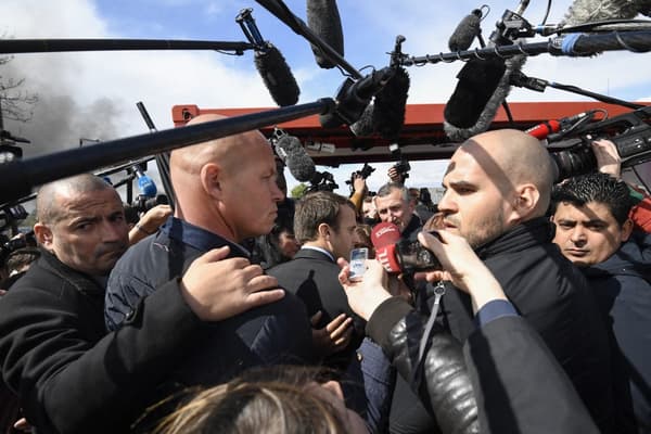 Emmanuel Macron entouré de ses gardes du corps, de perches de journalistes et d'ouvriers sur le parking de l'usine Whirlpool à Amiens le 26 avril 2017.