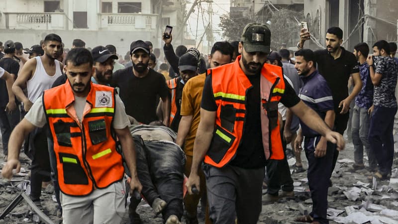 Des secouristes transportent le corps d'un homme tué lors d'une frappe israélienne à Rafah, dans le sud de la bande de Gaza, le 15 octobre 2023.