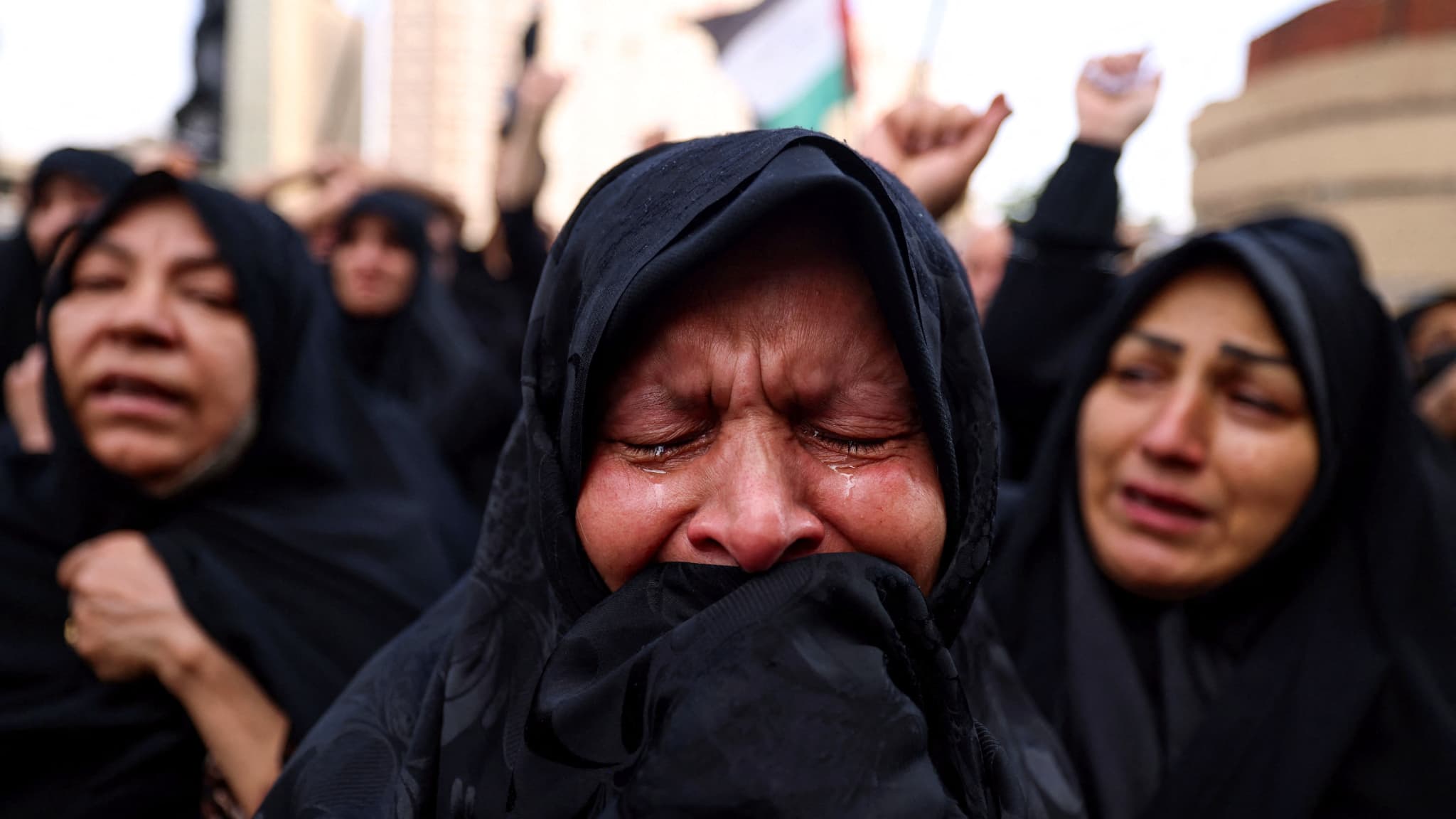 Une femme pleure alors que les Iraniens se rassemblent sur la place Valiasr, dans le centre de Téhéran, pour pleurer la mort du président Ebrahim Raïssi et du ministre des affaires étrangères Hossein Amir-Abdollahian dans un accident d'hélicoptère survenu la veille, le 20 mai 2024.