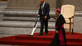Un employé passe l'aspirateur sur le tapis rouge autour de la chaise du pape François avant une célébration pénitentielle le 1er octobre 2024 à la basilique Saint-Pierre au Vatican.