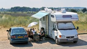 Des touristes en train de déjeuner devant leur camping-car près de La Graye-sur-Mer en Normandie (photo d'illustration).