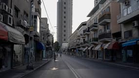 Des personnes circulent à vélo dans une rue vide pendant la fête juive de Yom Kippour à Tel Aviv, le 11 octobre 2024.