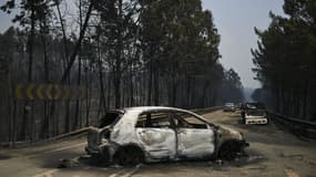 Une voiture brûlée sur une route traversant l'incendie, à Figueiro dos Vinhos, le 18 juin 2017 au Portugal.