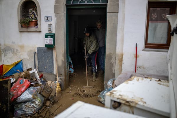 Des hommes nettoient une maison inondée à Montemurlo, à côté de Prato (Toscane, Italie), le 3 novembre 2023 après le passage de la tempête Ciaran