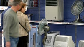 Des clients regardent les différents modèles de climatiseurs et de ventilateurs, le 15 avril 2004.