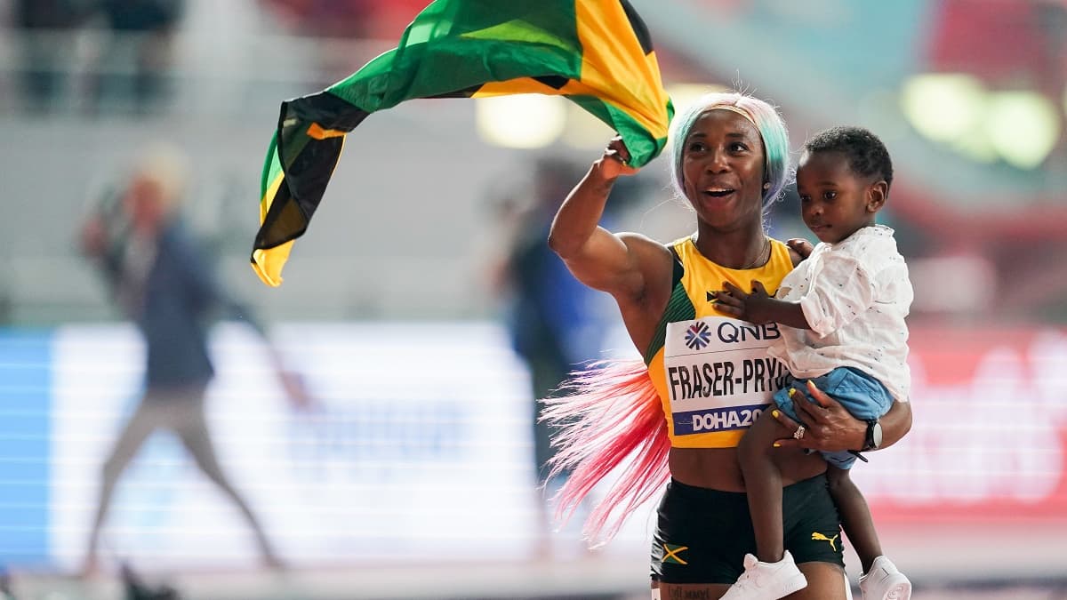 Shelly-Ann Fraser-Pryce fait son tour d'honneur avec son fils Zion après sa victoire en finale du 100 mètres féminin des Mondiaux de Doha