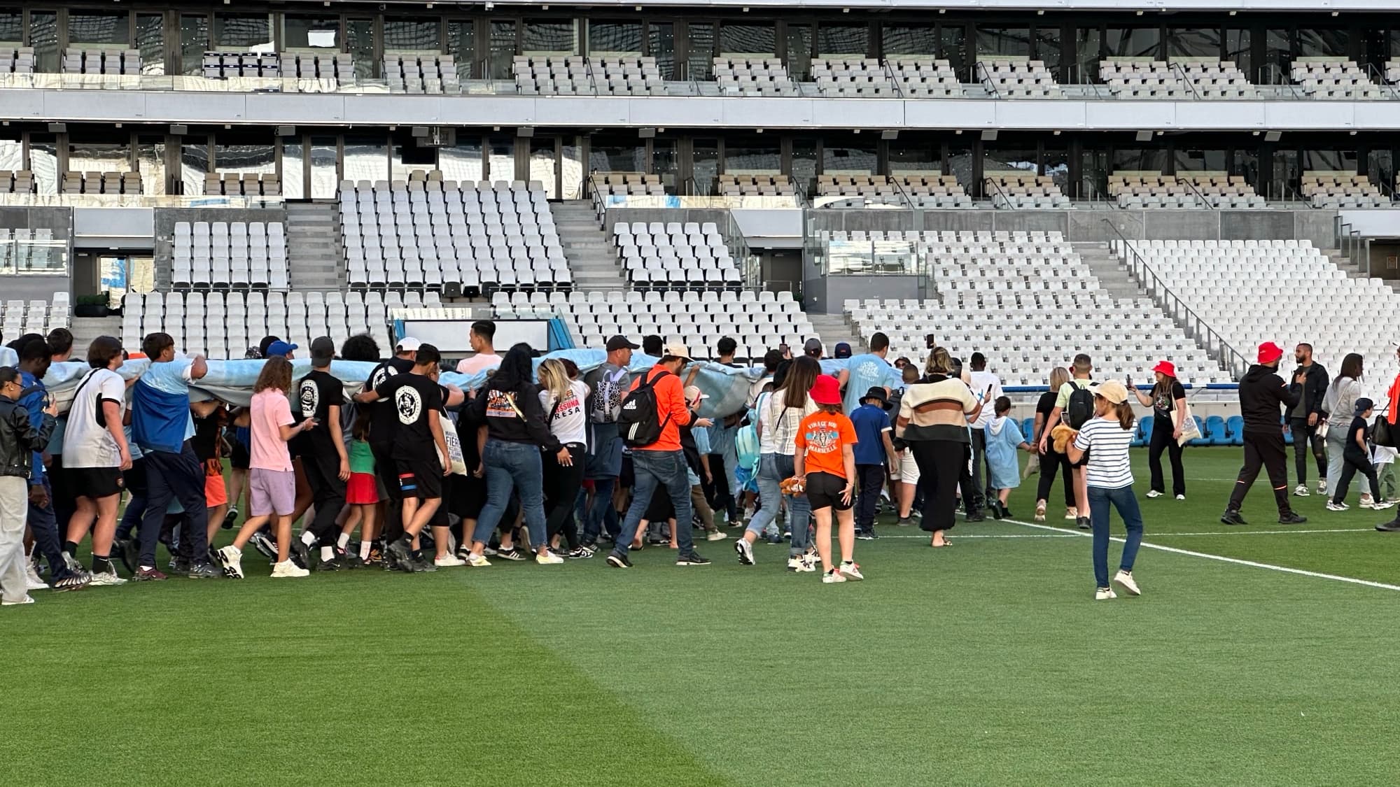 Des "minots" mettent en place un énorme tifo pour l'arrivée de la flamme olympique au stade Vélodrome, le 9 mai 2024.