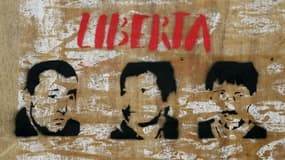 Les visages d'Yvan Colonna (g), Alain Ferrandi (c) et Pierre Alessandri (d) sous le mot "Liberté" sur un mur à Bastia, le 14 mars 2022 en Corse