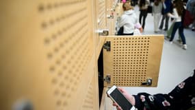Une élève dépose son téléphone portable dans un casier après l'avoir éteint, au collège Auguste Brizeux à Lorient, le 5 septembre 2024 dans le Morbihan.