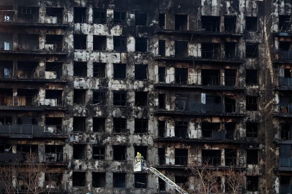 Des pompiers inspectent les conséquences d'un gigantesque incendie qui a ravagé hier un immeuble résidentiel de plusieurs étages, tuant au moins quatre personnes, à Valence, le 23 février 2024.