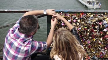 Un couple accroche un "cadenas d'amour" sur le pont des Arts le 29 mai 2015 à Paris