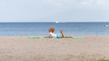 Un enfant en train de s'étirer sur la plage du Four Seasons Resort Punta Mita.
