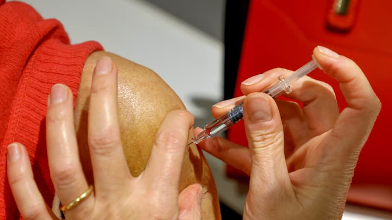 Un pharmacien vaccinant un patient contre la grippe en octobre 2020 à Paris