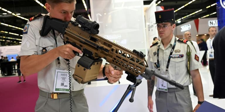 Un militaire français tient un fusil d'assaut du fabriquant belge FN Herstal au salon international de défense Eurosatory à Villepinte, près de Paris, le 13 juin 2022
