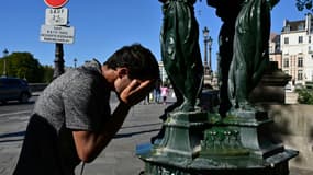Un homme se rafraîchit le visage à une fontaine publique à Paris, le 21 août 2023