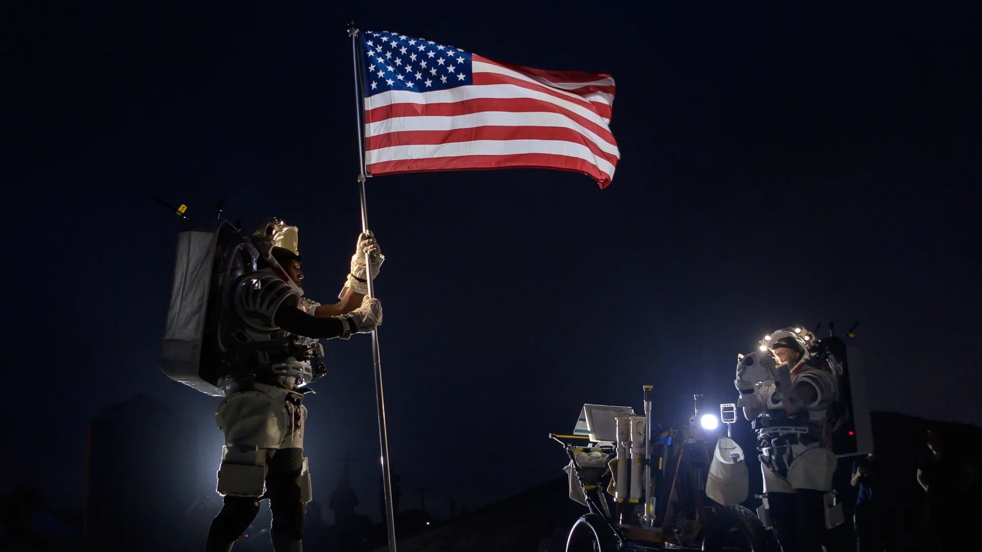 L'astronaute de la NASA Kate Rubins (à droite) prend une photo de l'astronaute de la NASA Andre Douglas (à gauche) alors qu'il lève un drapeau américain lors d'une simulation de marche sur la Lune dans le désert de l'Arizona