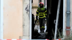 Un pompier dans le bâtiment où s'est déclaré dans la nuit un incendie mortel à Neuves-Maisons, en Meurthe-et-Moselle, le 30 novembre 2025 
