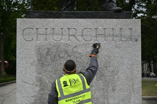 Nettoyage de la statue de l'ancien Premier ministre britannique Winston Churchill pour ôter un graffiti affirmant qu'il "était un raciste", à Londres le 8 juin 2020 Nettoyage de la statue de l'ancien Premier ministre britannique Winston Churchill pour ôter un graffiti affirmant qu'il "était un raciste", à Londres le 8 juin 2020