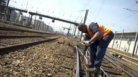 Un agent de la SNCF entretient le réseau à Paris le 14 juillet 2013.